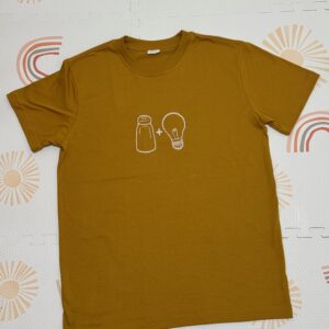 Salt & Light Tees embroidered in cream thread as a line art of salt and light icons. Shirt color is in mustard.